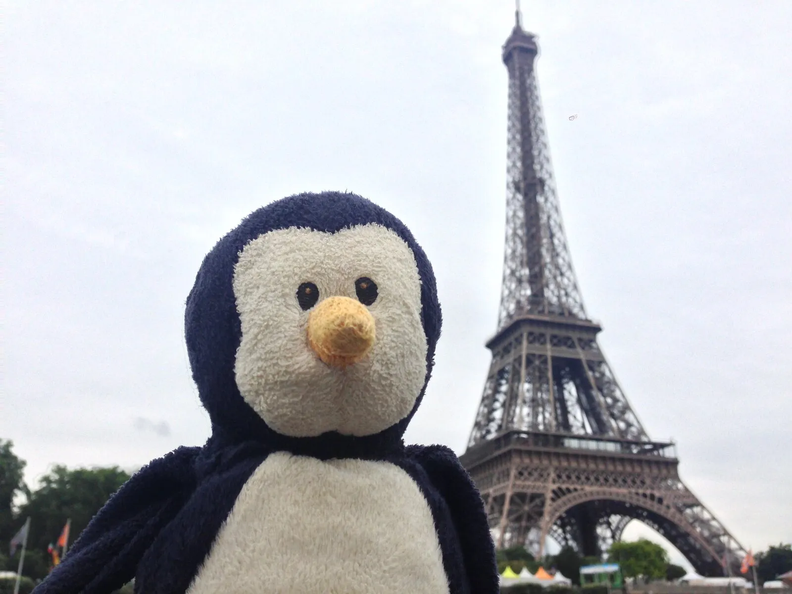 Penguinoh close up in front of the Eiffel Tower